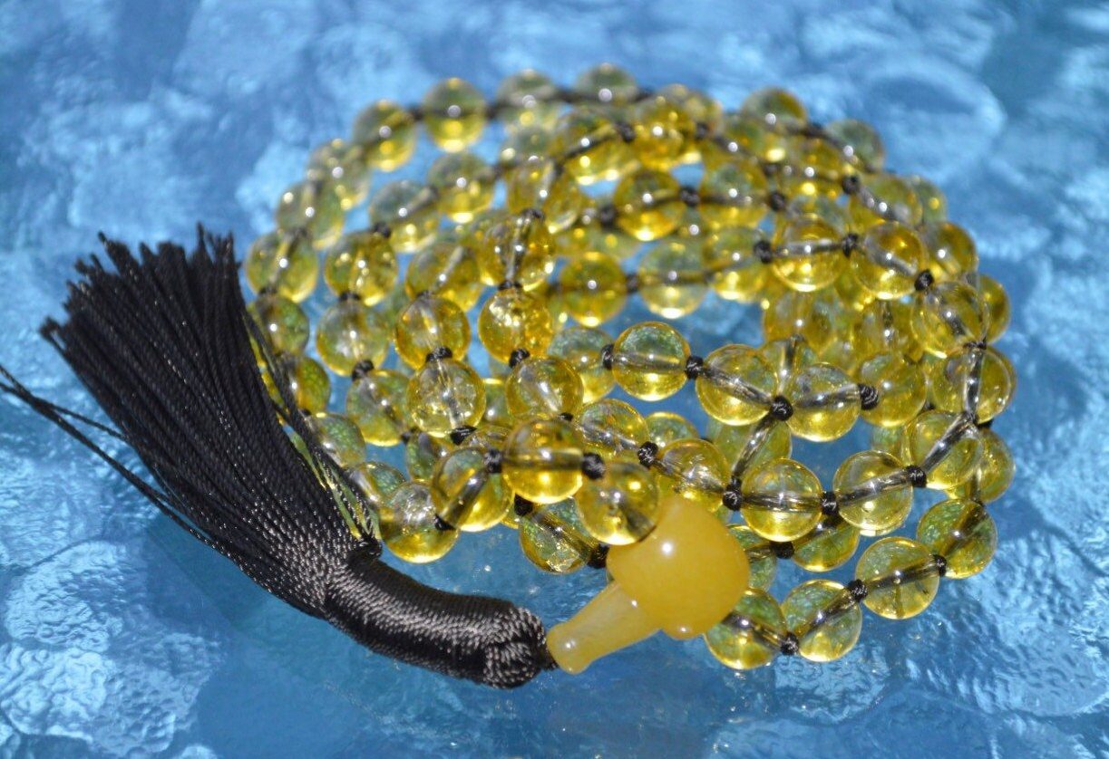 Knotted Citrine Mala Necklace featuring 108 hand-knotted Citrine beads, designed to enhance abundance, positivity, and personal power. Aligns with the Solar Plexus Chakra and resonates with Gemini and Leo. Perfect for meditation and daily wear.