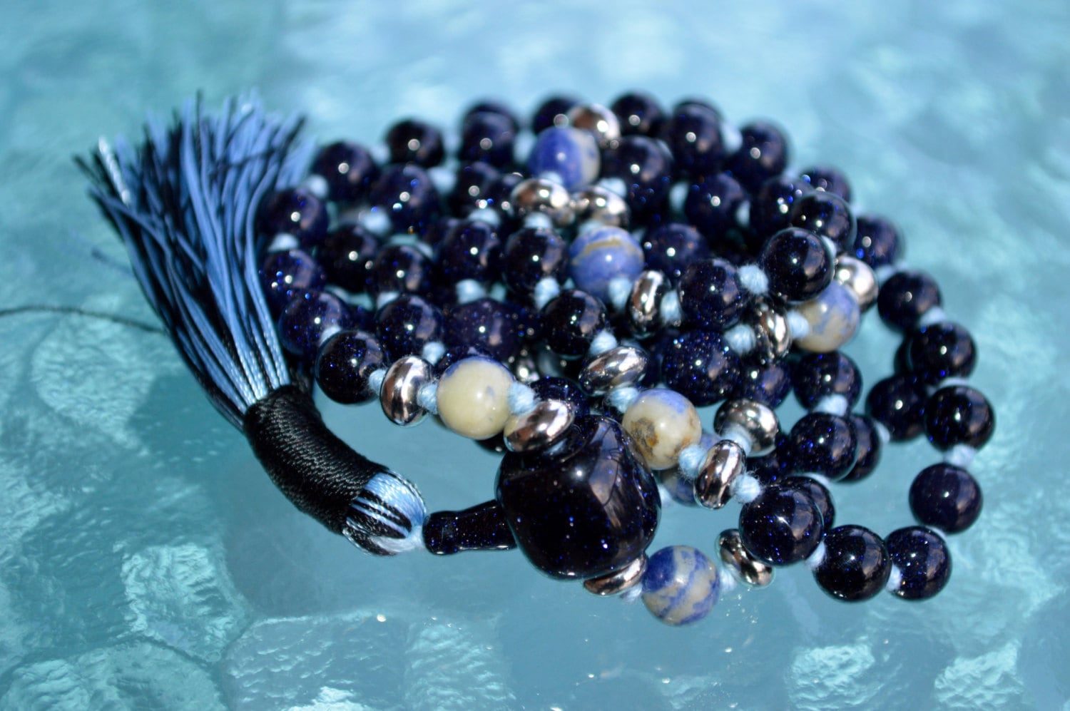 Galaxy Stone Blue Goldstone Mala Necklace featuring shimmering Blue Goldstone beads, hand-knotted, associated with Root and Throat Chakras for ambition and protection, aligned with Sagittarius.